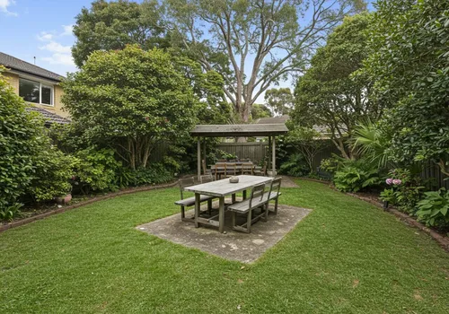 Lush green backyard with mature trees in a Poolesville neighborhood, the type of shaded yard where mosquitoes breed near Dry Seneca Creek