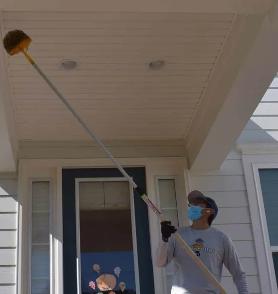 Better Termite technician treating entry points around the porch of an Odenton Maryland home