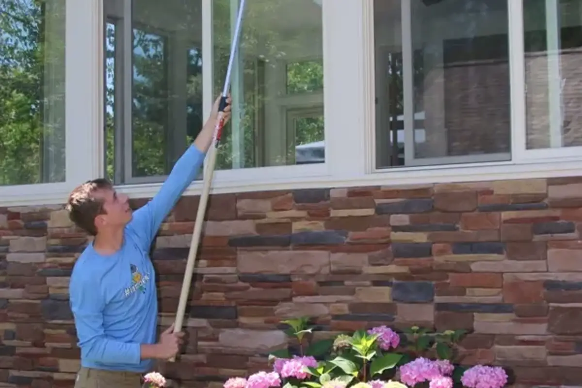 Better Termite technician dewebbing the eaves of a Northern Virginia home
