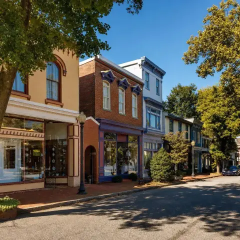 Historic Antique Row storefronts on Howard Avenue in Kensington, Maryland with mature shade trees and brick sidewalks