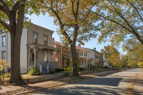 Tree-lined street of older wood-frame and brick houses in the historic district of Laurel, Maryland in early fall