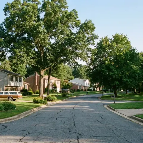 Suburban street in Lorton Virginia with mature trees, split-level homes, and a quiet residential neighborhood near parkland