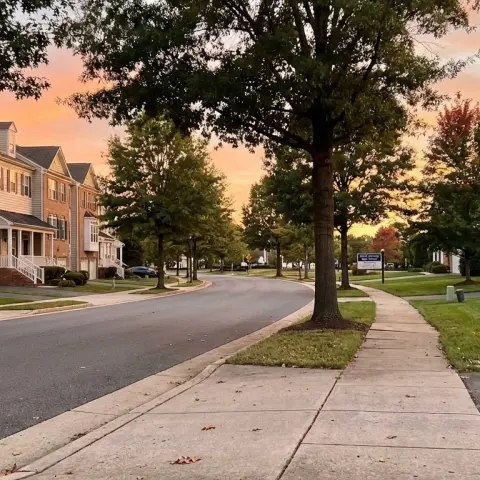 Suburban neighborhood street in Lorton Virginia Fairfax County with townhomes and mature trees