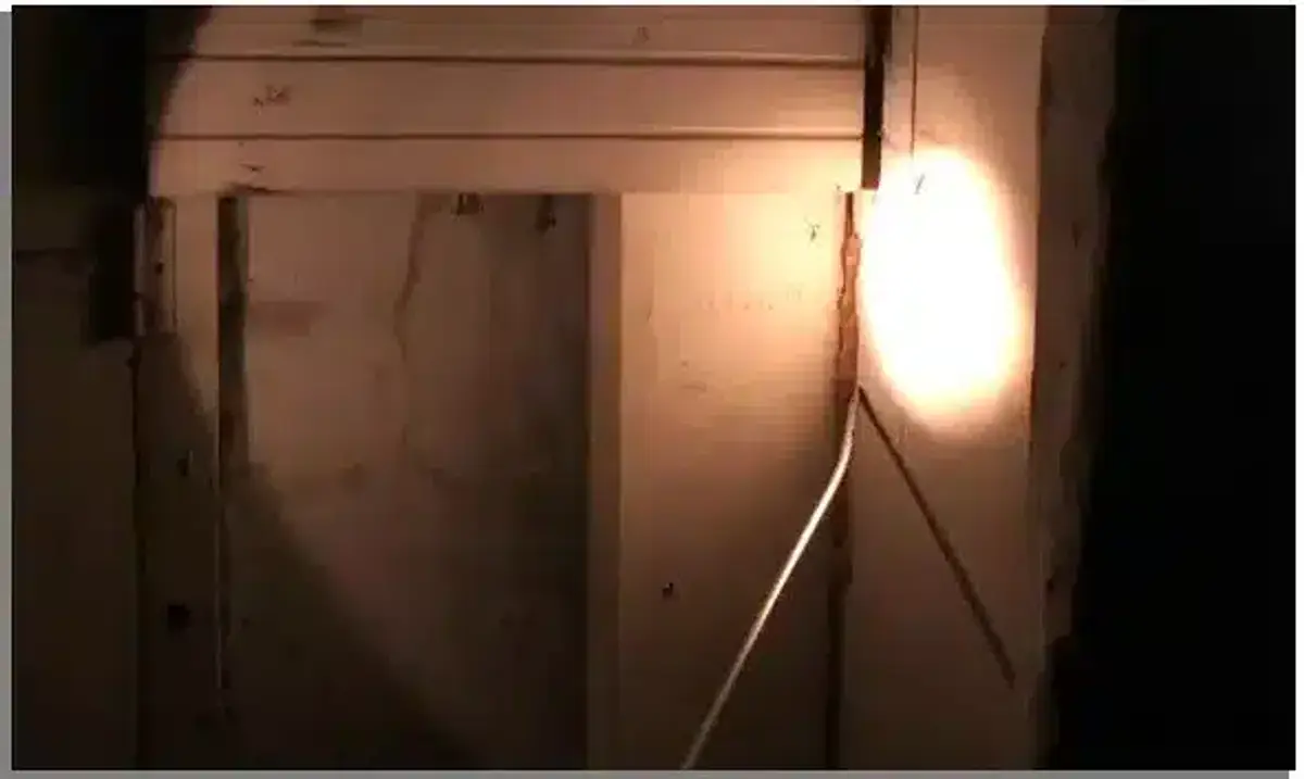 Flashlight shining into a dark corner during a termite inspection