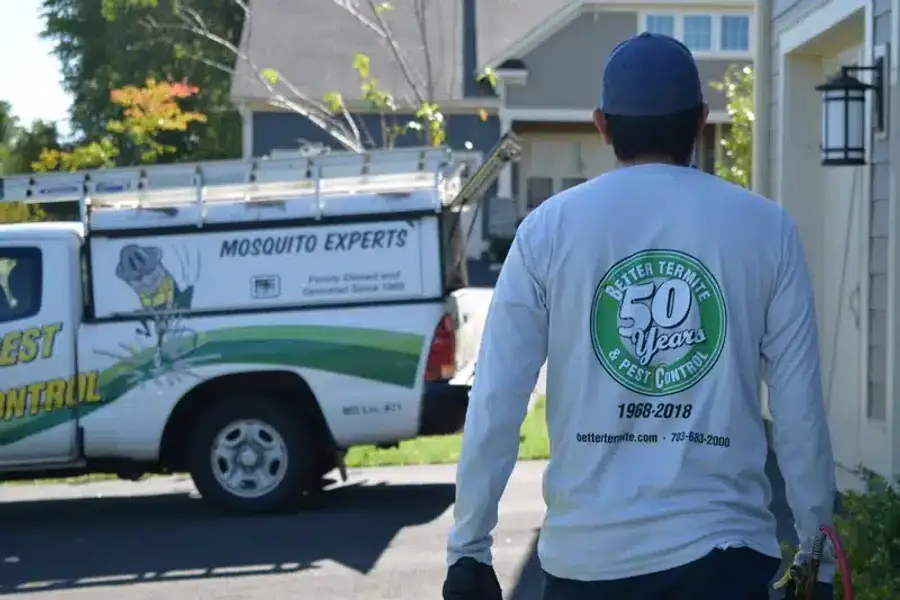 Pest control technician walking outside home
