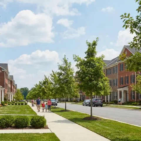 Suburban neighborhood street in Urbana Maryland with colonial-style townhomes and landscaped sidewalks