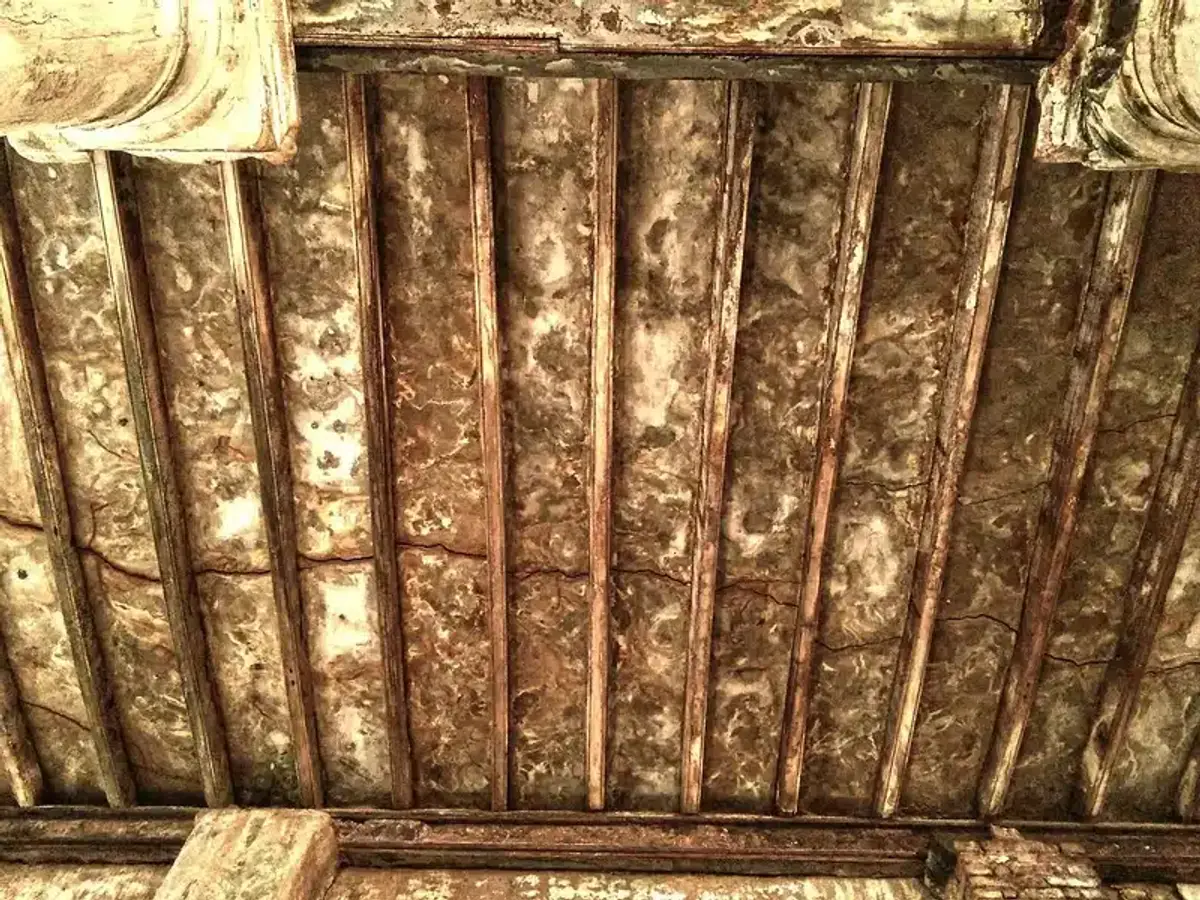 Weathered wooden ceiling with stains from moisture damage